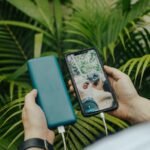 faceless person transferring data from smartphone to hard drive